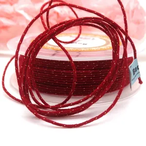 Detailed macro shot of red braided cotton cord with sparkling gold thread for jewelry DIY
