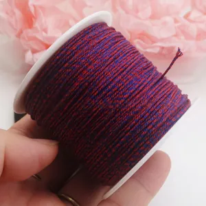 Nahaufnahme einer 0,8 mm dicken, rot-blauen Baumwollschnur auf Spule für DIY-Schmuck.