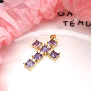 Detailed view of gold-plated cross pendant with square purple zircon stones