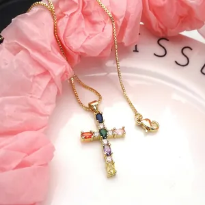 Detailed view of gold copper necklace with multi-colored oval CZ cross pendant
