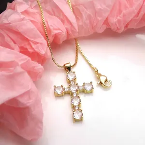 Detailed view of gold plated cross pendant necklace with sparkling round cubic zirconia