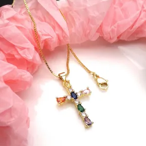 Detailed view of gold cross pendant featuring vibrant multi-colored teardrop zircons.