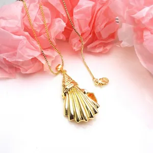 Macro view of an elegant gold seashell pendant on a dainty box chain necklace