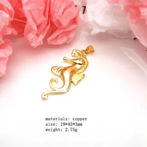 Detailed macro view of a golden copper seahorse pendant on white surface