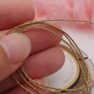 Detailed macro shot of 0.8mm gold twisted cotton jewelry cord showing fine woven texture.