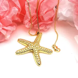 Macro view of a gold-colored starfish pendant necklace featuring a beaded texture