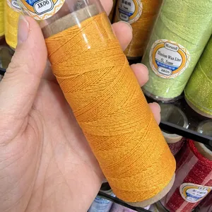 Close-up of bright orange metallic waxed thread spool for DIY jewelry weaving