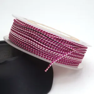 Macro view of 1.5mm purple and pink braided dragon pattern cord wound on a spool.