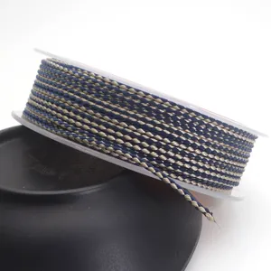 Close-up detail of 1.5mm navy and gold braided dragon pattern cord on a white spool