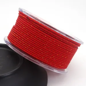Close-up of 1.5mm red Milan cord with gold silk threads wound on a clear spool