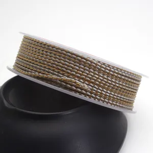 Detailed macro view of 1.5mm gold and silver dragon pattern braided cord on a white spool