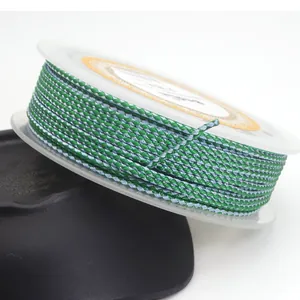 Macro detail of 1.5mm green and blue dragon pattern braided cord on a transparent spool