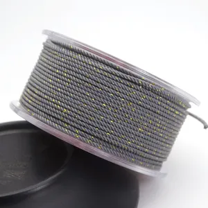 Detailed macro view of 1.5mm gray Milan cord with gold metallic silk thread on clear spool