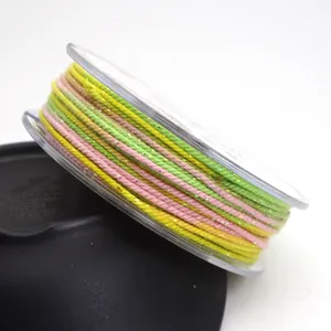Detail shot of 1.2mm multicolored cotton cord with metallic gold thread on a spool