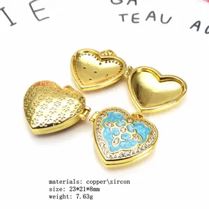 Detail of heart locket pendant with blue enamel, zircon border, and floral patterns