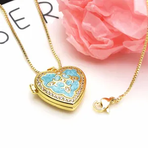 Detailed macro shot of a heart-shaped gold-plated locket with light blue enamel and zircon