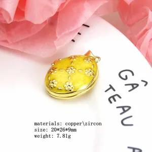Close-up detail showing the intricate floral pattern on a gold-plated copper locket pendant.
