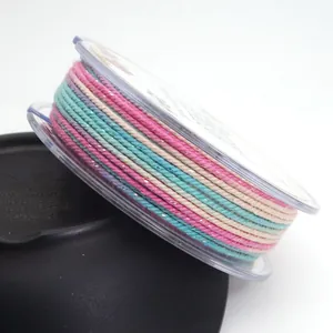 Macro view of 1.2mm multicolor gradient cotton cord with metallic glitter on a transparent spool