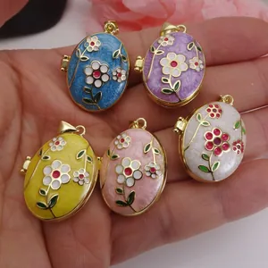 Group of five colorful floral enamel locket pendants held in hand