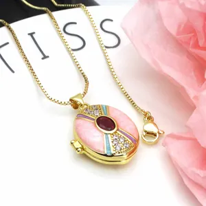 Detailed view of an ornate gold-plated locket necklace featuring pink enamel and zircons