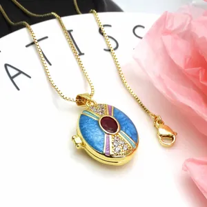Detailed close-up of gold-plated copper locket with blue enamel and red zircon stone