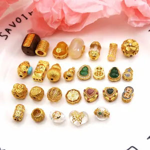 Detailed view of various gold-plated zircon charms for DIY jewelry making