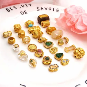 Detailed macro view of assorted sand gold charms and beads for DIY jewelry making