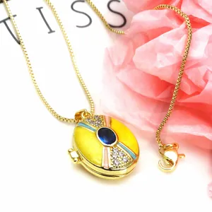 Detailed view of oval enamel locket necklace with blue gemstone and zircon inlay