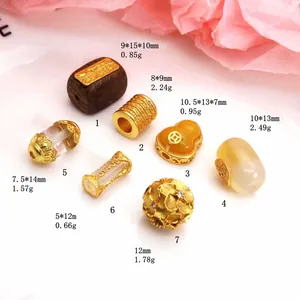 Close-up of assorted gold-plated jewelry beads showing specific sizes and weights