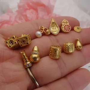 Vue macro de divers breloques bijoux DIY en or des sables avec incrustation de zircon