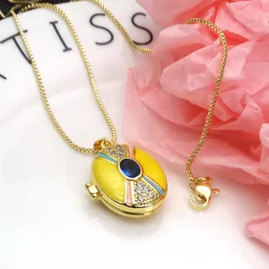 Close-up detail of yellow enamel locket necklace with zircon inlay and gold-plated chain