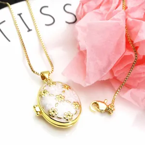 Detailed view of the gold-plated floral oval locket with a delicate chain