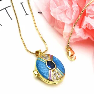 Detailed view of a gold-plated oval locket necklace with blue enamel and sparkling zircons.