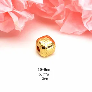 Detailed macro view of golden dragon scale textured cube bead for DIY jewelry making