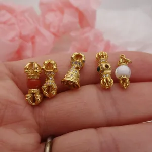 Close-up detail view of sand gold Buddhist Vajra charms with zircon for DIY bracelet making