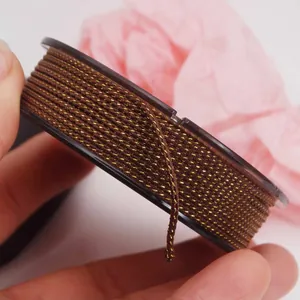 Macro view of 1.5mm brown braided cord with gold metallic threads for DIY jewelry