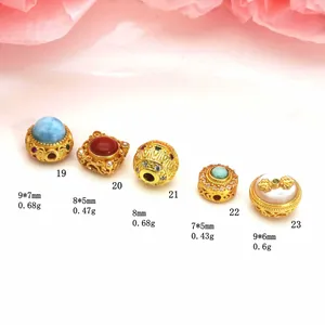 Detail view of various gold-plated beads with stone inlays and weight specs