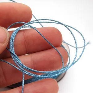Detailed macro shot of 0.85mm iridescent blue jade thread for DIY jewelry weaving