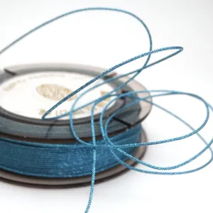 High-quality macro detail of 0.85mm teal metallic braided jade thread for DIY