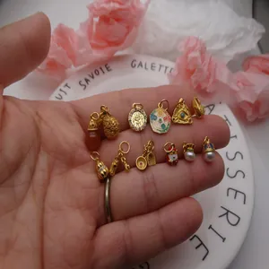 Muestra manual de varios dijes chapados en oro para accesorios de joyería DIY