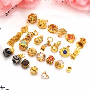 Collection of sand gold DIY jewelry charms including Dzi beads and gourd pendants.