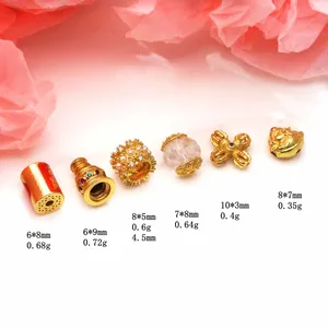 Vista detallada de dijes dorados para joyería DIY, incluyendo coronas y separadores vajra.