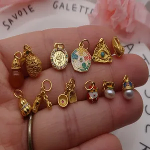Variedad de dijes DIY bañados en oro, incluyendo bolsas de la suerte y coronas en la palma