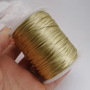Gros plan détaillé sur un cordon de noeud chinois doré pour le tressage DIY sur une bobine