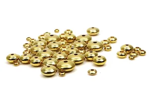 Nahaufnahme von goldenen massiven Messing-Abakus-Zwischenperlen für DIY-Schmuck