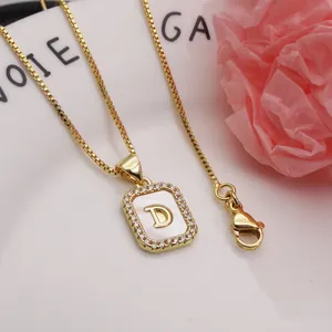 Close-up of gold shell initial D pendant necklace with cubic zirconia detailing.