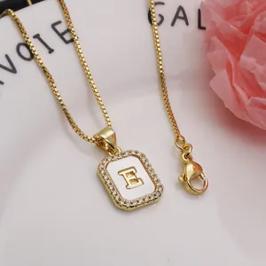 Detailed close-up of square initial E pendant necklace with zircon and shell inlay