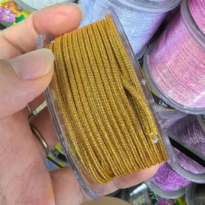 Macro detail of 2.0mm gold metallic braided cord on spool for DIY jewelry crafts