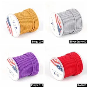 Close-up of Milanese thread spools in beige, silver gray, purple, and red colors.