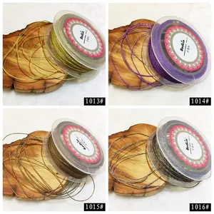 Close-up view of 1mm metallic jewelry cords in various colors on spools with wood background